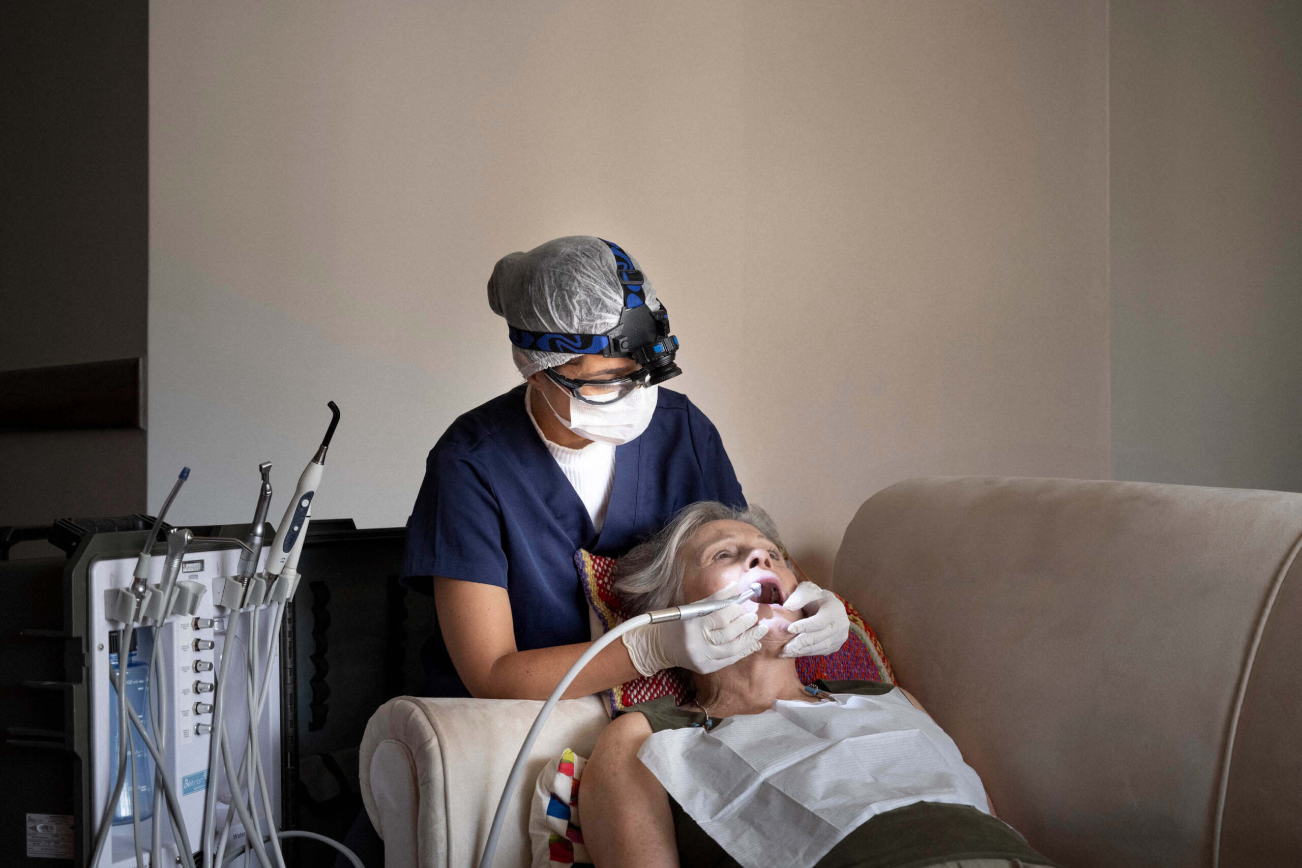 Dentista realizando atendimento odontológico domiciliar em idoso